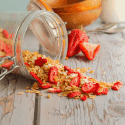 strawberry coconut granola spilling out of jar