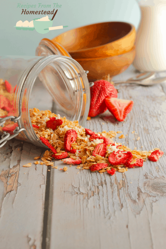 strawberry coconut granola spilling out of jar