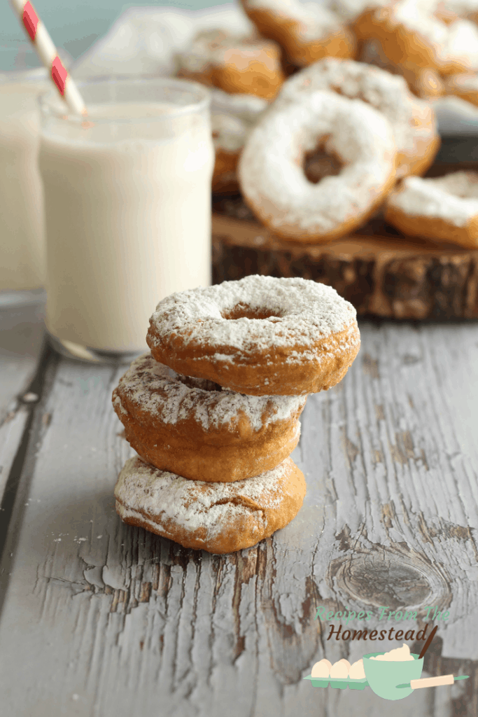 3 donuts stacked with milk in back